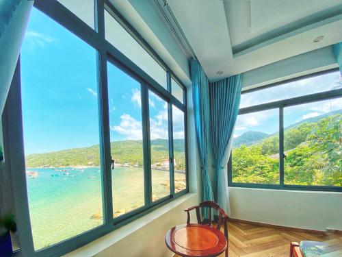 a room with large windows looking out at the beach at Coco Bay Hon Son in Lai Sơn