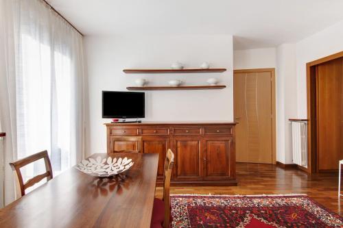 a living room with a wooden table and a television at Apartment Bossi View in Chiavenna