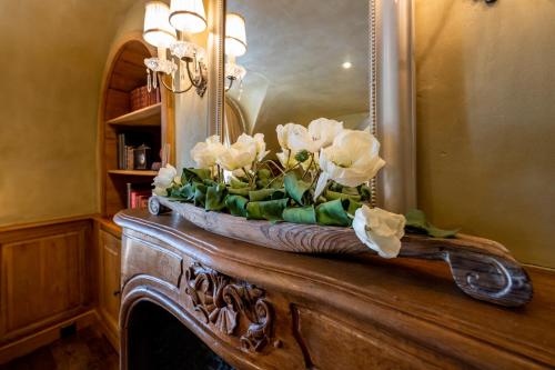 a vase of flowers sitting on top of a fireplace at LeSable luxury vacation home in Kluisbergen