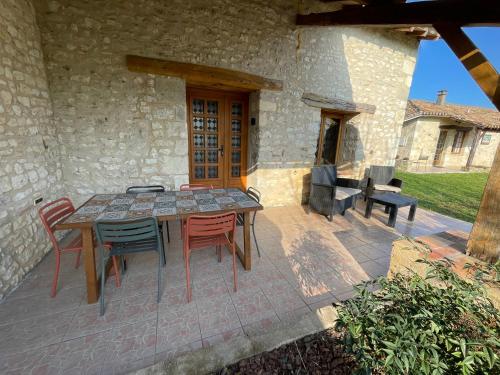 a patio with a table and chairs on a patio at Le Clos des 4 Bastides in Saint-Eutrope-de-Born