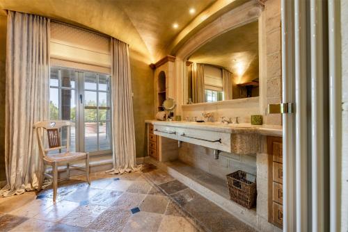 a bathroom with a sink and a mirror and a chair at LeSable luxury vacation home in Kluisbergen