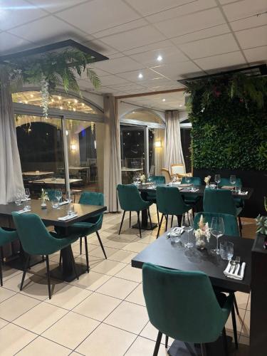 a dining room with tables and green chairs at Acapella Hotel in Argelès-sur-Mer