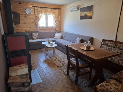 a living room with a couch and a table at Green cottage in Blidinje