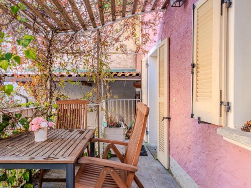 a wooden table and a chair on a patio at Holiday Home Casetta Rosa by Interhome in San Siro