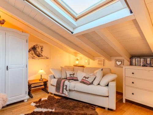 a living room with a white couch and a skylight at Holiday Home Casetta Rosa by Interhome in San Siro