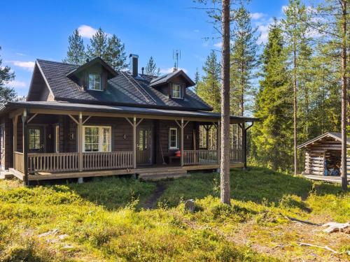 ein Haus mit einer umlaufenden Veranda im Wald in der Unterkunft Holiday Home Kiehtäjän kuohu by Interhome in Käylä