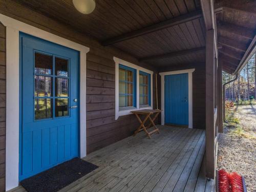 une terrasse couverte à l'avant d'une maison avec portes bleues dans l'établissement Holiday Home Marjarinne 8 a by Interhome, à Levi