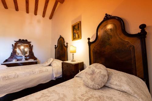 a bedroom with two beds and a mirror on the wall at Fattoria Poggio Capponi in Montespertoli