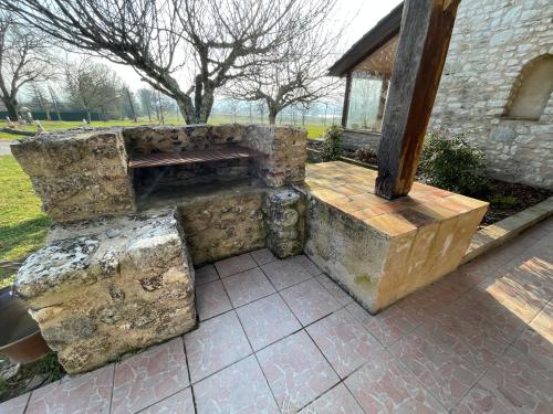 a stone bench sitting next to a building at Le Clos des 4 Bastides in Saint-Eutrope-de-Born