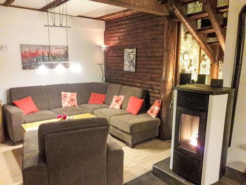 ein Wohnzimmer mit Couch und Kamin in der Unterkunft Holiday Home Knusperhaus Gretel by Interhome in Frankenau