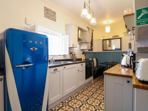 an old blue refrigerator in a kitchen with a sink at The Hideout in Oakham