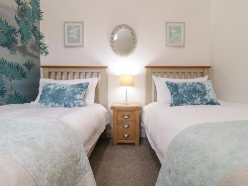 a bedroom with two beds and a mirror on the wall at The Hideout in Oakham