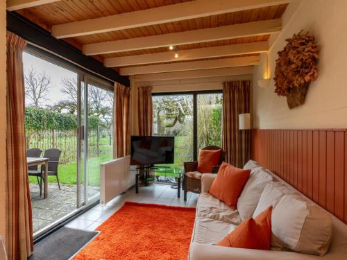 a living room with a white couch and a television at Holiday Home Buitenplaats Schouwen nr 86 by Interhome in Burgh Haamstede