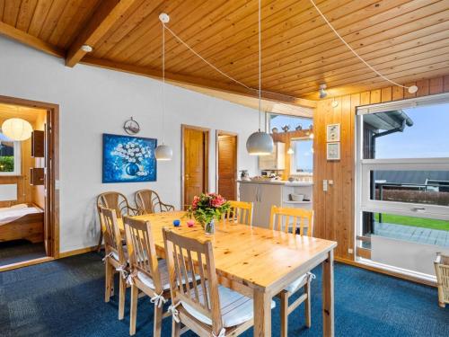 a dining room with a wooden table and chairs at Holiday Home Slava - 75m from the sea by Interhome in Hesselager