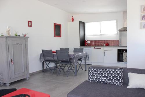 une cuisine et un salon avec une table et des chaises dans l'établissement Gite du Becquet, à Le Rozel