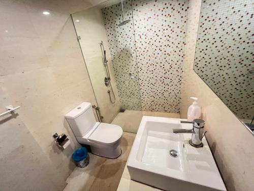 a bathroom with a toilet and a sink and a shower at Regalia Spritz Empire Hostel in Kuala Lumpur