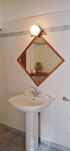 Baño con lavabo con una luz sobre él en Amuse Bush Villa, en Mahe