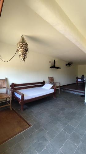 a large room with a bed and two chairs at Espaço Akronos Residence in Canoa Quebrada