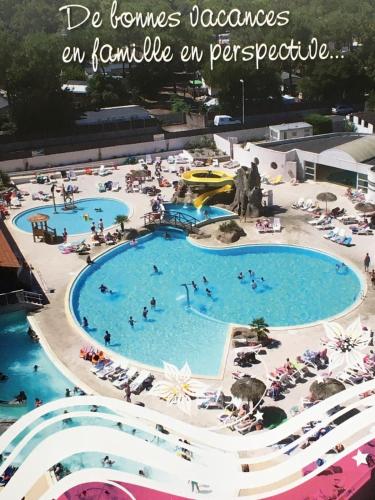 - une piscine dans un complexe avec des personnes dans l'eau dans l'établissement MH climatisé 4P camping La Yole St Jean de Monts, à Saint-Jean-de-Monts