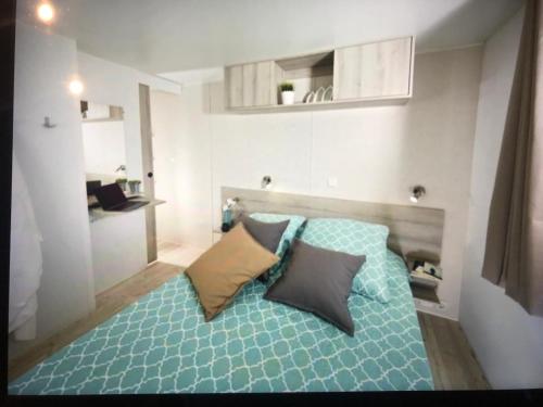 une chambre avec un lit avec deux oreillers dessus dans l'établissement MH climatisé 4P camping La Yole St Jean de Monts, à Saint-Jean-de-Monts