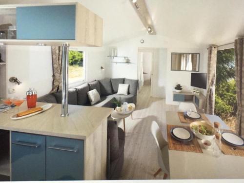 une cuisine et un salon avec un canapé et une table dans l'établissement MH climatisé 4P camping La Yole St Jean de Monts, à Saint-Jean-de-Monts