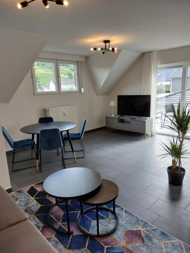 a living room with a couch and a table and a tv at FeWo's Weinbergblick Wintrich by Brauneberger Hof in Wintrich