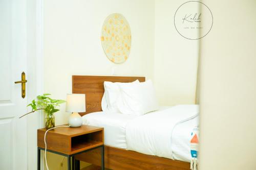 a bedroom with a bed and a table with a lamp at Kalih Villa in Kigali