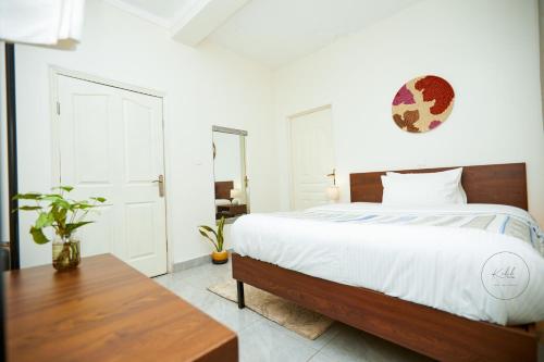 a bedroom with a large bed and a wooden table at Kalih Villa in Kigali