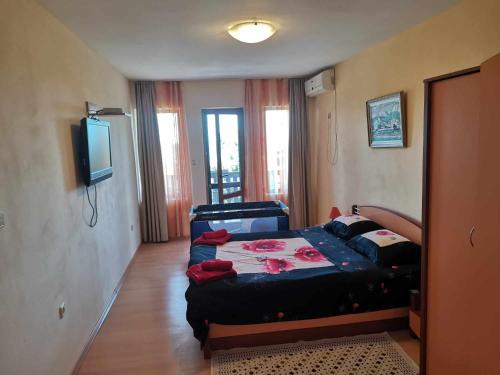 a bedroom with a bed and a flat screen tv at Villa Holly in Balchik