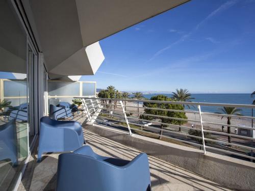 d'un balcon avec des chaises bleues et une vue sur l'océan. dans l'établissement Apartment Le Chantilly-3 by Interhome, à Cagnes-sur-Mer