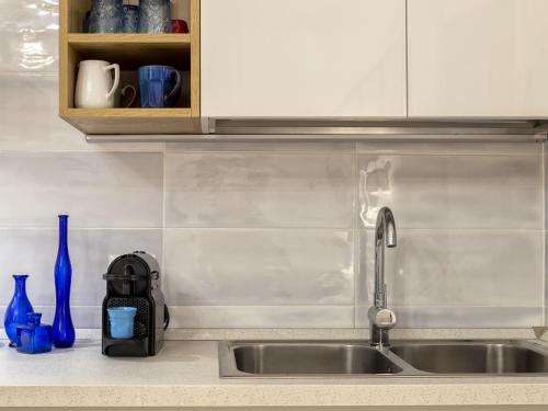 a kitchen sink with a faucet and blue vases at Apartment La casa dei Cestini by Interhome in Agrustos