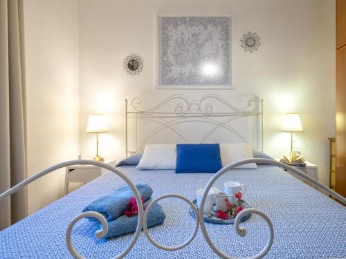a bedroom with a white bed with a blue bedspread at Apartment La casa dei Cestini by Interhome in Agrustos