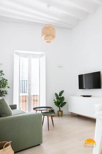 a living room with a couch and a tv at Villalobos by Cadiz Time in Cádiz