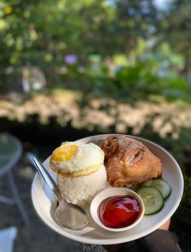 a plate of food with an egg and other foods at Manalo Resort Hotel in Tutulo