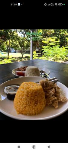 a white plate with some food on a table at Manalo Resort Hotel in Tutulo