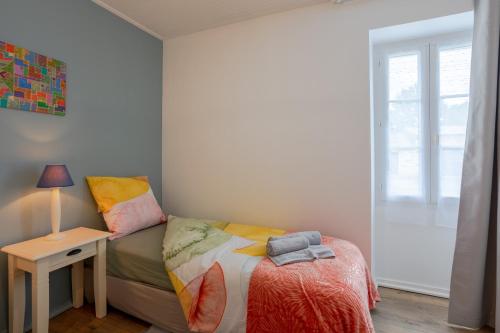 a small bedroom with a bed and a table at Gite de la Bouliniere in Challans