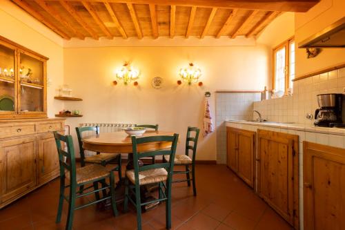 a kitchen with a wooden table and chairs at Fattoria Poggio Capponi in Montespertoli