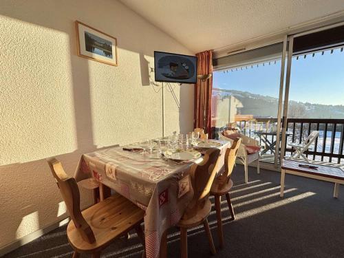 une salle à manger avec une table et des chaises et un balcon dans l'établissement Studio cosy au pied des pistes avec piscine et parking - 4 pers - FR-1-595-19, à Notre-Dame-de-Bellecombe