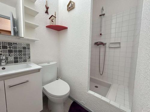a white bathroom with a toilet and a shower at Studio cosy au pied des pistes avec piscine et parking - 4 pers - FR-1-595-19 in Notre-Dame-de-Bellecombe
