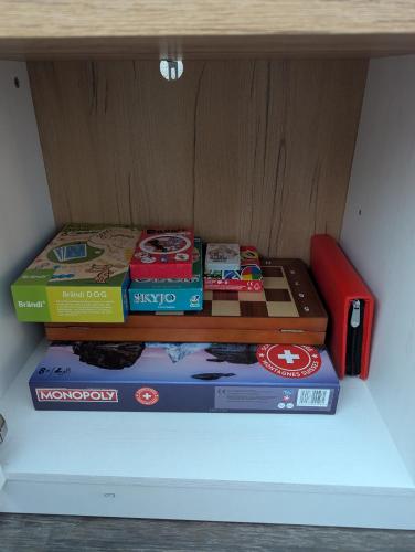 a stack of books sitting on top of a shelf at Ski-In, ski-out Thyon in Vex