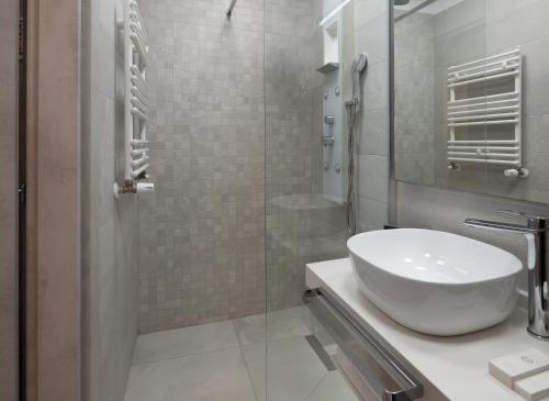 a bathroom with a sink and a glass shower at Novos Luxury Suites in Bucharest