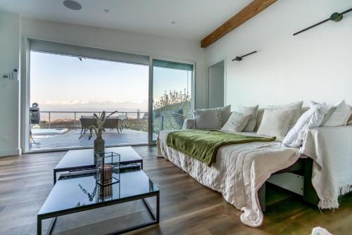 un salon avec un lit et une grande fenêtre dans l'établissement Maison 4 chambres avec jaccuzi piscine privée et sauna, à Apremont