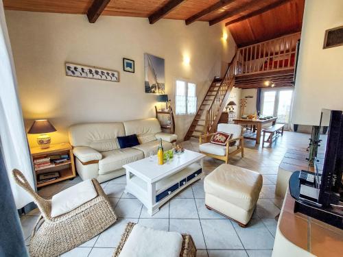 ein Wohnzimmer mit Sofa und Tisch in der Unterkunft Holiday Home Charme de la Grande Bosse by Interhome in LʼÉpine