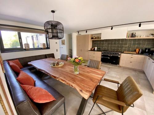 eine Küche und ein Esszimmer mit einem Holztisch in der Unterkunft Holiday Home Seascape Wellness Nieuwvliet-Bad by Interhome in Nieuwvliet-Bad