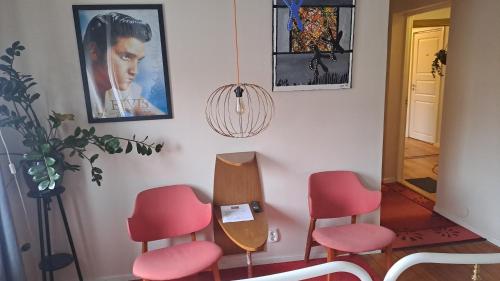 a room with pink chairs and a mirror at Sveriges minsta Hotell! Hôtel Gruyère in Landskrona
