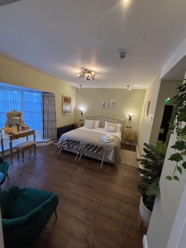 a bedroom with a bed and a table and a window at The Cherry Tree Hotel in Chinnor