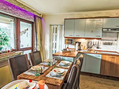 une cuisine avec une table et des chaises en bois ainsi qu'une cuisine avec un comptoir dans l'établissement Apartment Ruhrtalblick by Interhome, à Winterberg