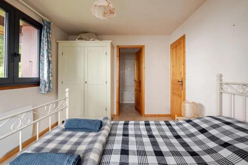 a bedroom with a bed with a checkered blanket at Chalet confortable avec vue sur la montagne à Peisey-Nancroix in Peisey-Nancroix