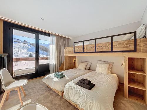 une chambre avec un lit superposé et une grande fenêtre dans l'établissement Apartment Péclet 305 by Interhome, aux Menuires