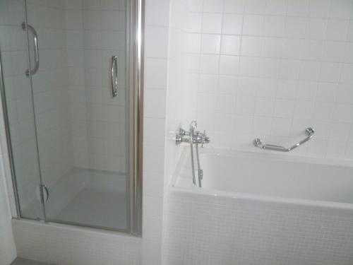 a bathroom with a shower and a tub and a sink at Hotel DAP in Prague